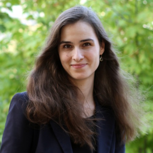 Julia Netter sitting with hands crossed in a black suit