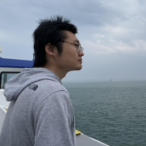 Shichen Wang looking out over body of water.
